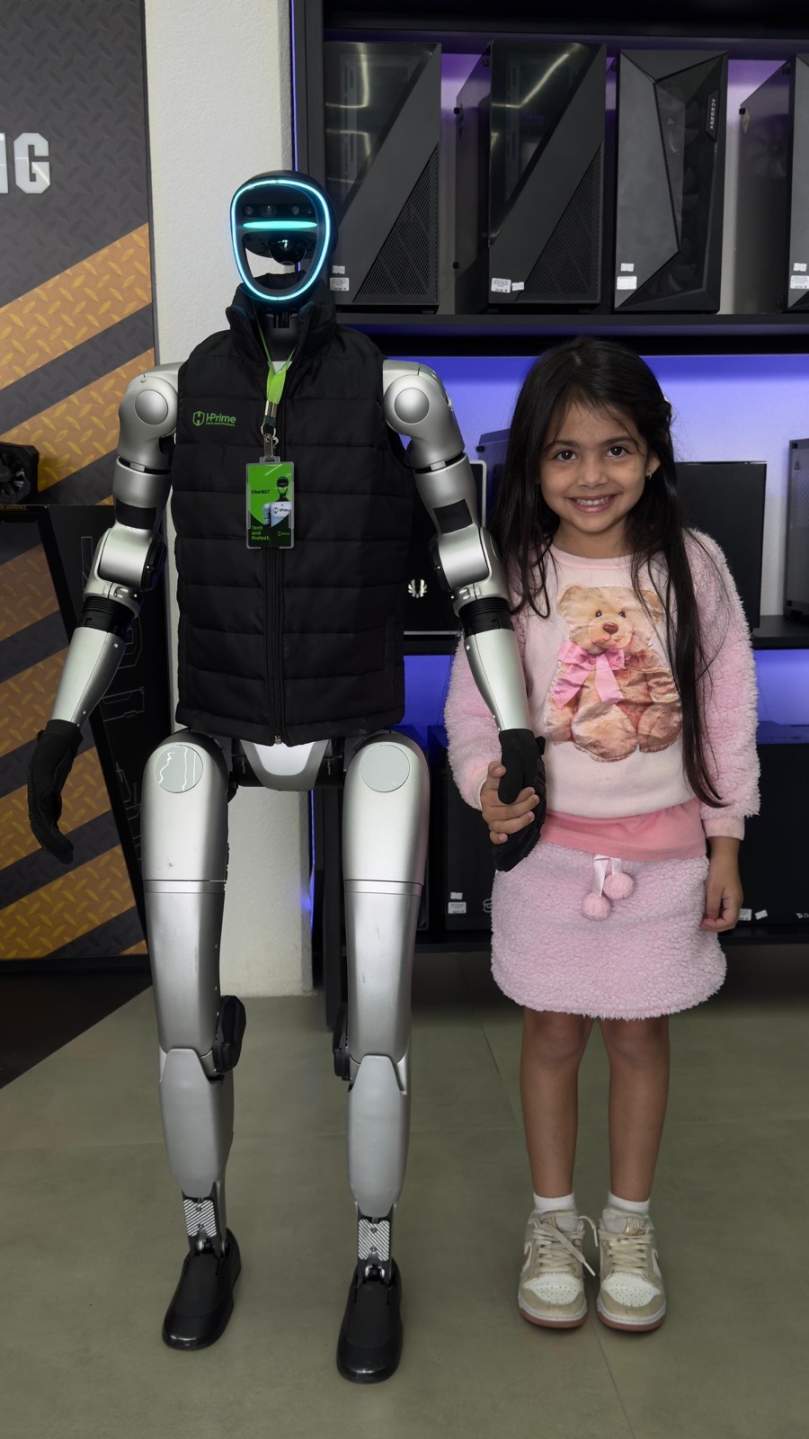 Humanoide G1 em evento de games ao lado de personagem